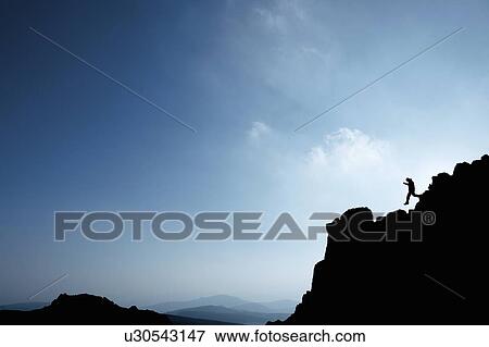 Man hiking on rocky hillside View Large Photo Image Stock Photo - Man hiking on rocky hillside. Fotosearch