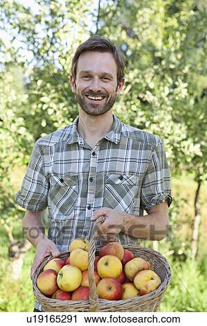 Man holding basket of apples View Large Photo Image Stock Image - Man holding basket of apples. Fotosearch