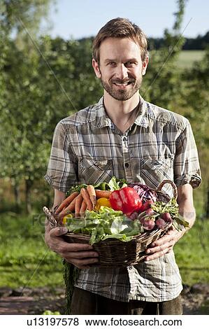 Man holding basket of vegetables View Large Photo Image Stock Photo - Man holding basket of vegetables. Fotosearch