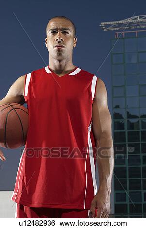 Man holding basketball on rooftop View Large Photo Image Stock Photograph - Man holding basketball on rooftop. Fotosearch