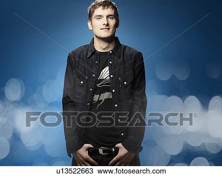 Stock Image - Man holding his belt buckle. Fotosearch