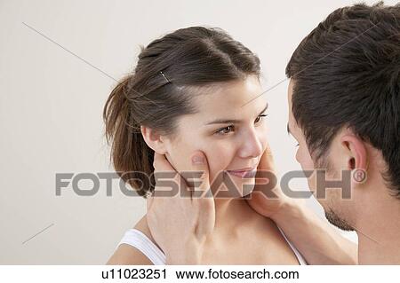 Man holding his girlfriend's face View Large Photo Image Stock Image - Man holding his girlfriend's face. Fotosearch