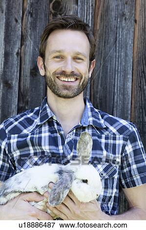 Man holding rabbit outdoors View Large Photo Image Stock Photo - Man holding rabbit outdoors. Fotosearch