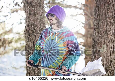 Man in hoody shoveling snow View Large Photo Image Stock Photograph - Man in hoody shoveling snow. Fotosearch