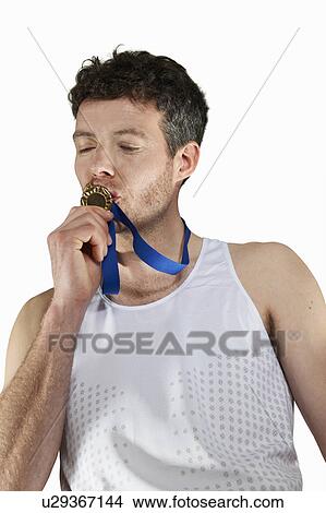 Man in running gear kissing medal View Large Photo Image Picture - Man in running gear kissing medal. Fotosearch