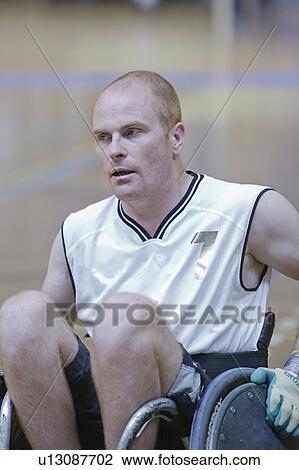 Stock Image - Man in wheelchair playing indoor sports. Fotosearch