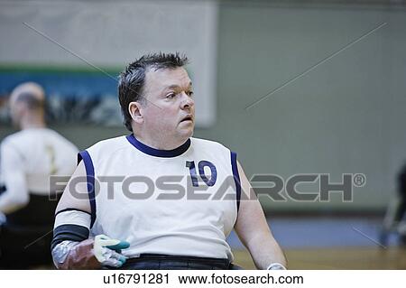 Stock Image - Man in wheelchair playing indoor sports. Fotosearch