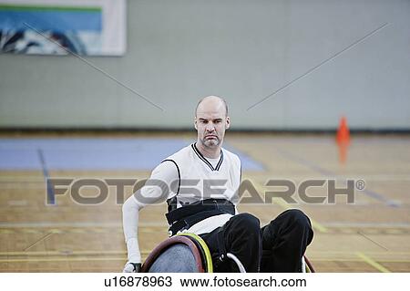 Stock Image - Man in wheelchair playing indoor sports. Fotosearch