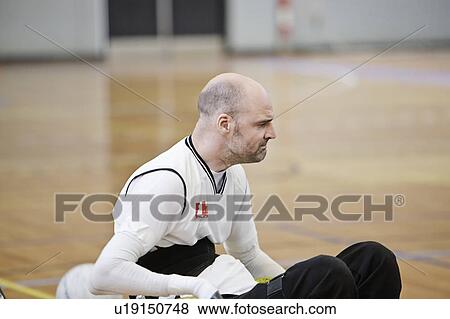 Stock Photo - Man in wheelchair playing indoor sports. Fotosearch