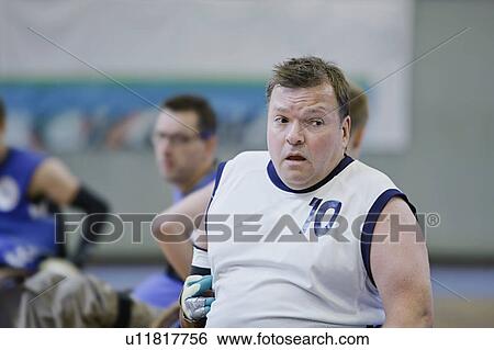 Stock Photograph - Man in wheelchair playing indoor sports. Fotosearch