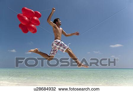 Man jumping with balloons on beach View Large Photo Image Stock Image - Man jumping with balloons on beach. Fotosearch