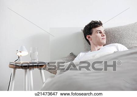 Man laying in bed View Large Photo Image Stock Photo - Man laying in bed. Fotosearch