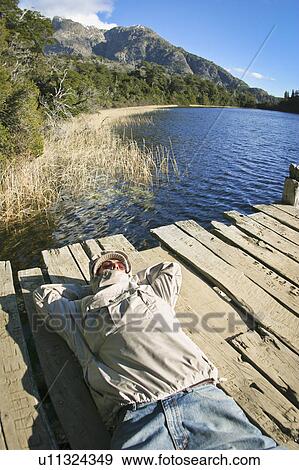 Man laying on dock View Large Photo Image Stock Photo - Man laying on dock. Fotosearch