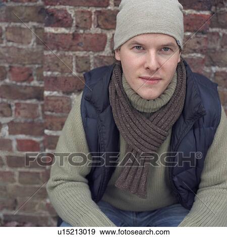 Stock Photo - Man leaning against brick wall. Fotosearch