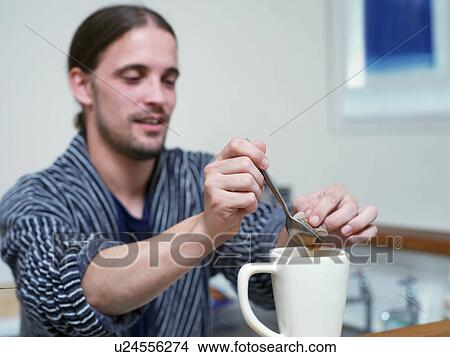 Picture - Man making cup of tea in kitchen. Fotosearch