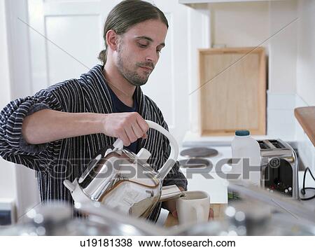 Man making cup of tea in kitchen View Large Photo Image Stock Photo - Man making cup of tea in kitchen. Fotosearch