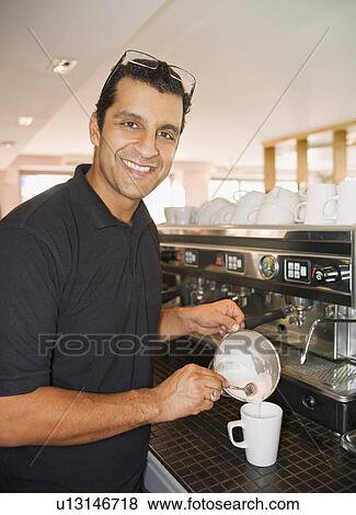Man pouring foamed milk into coffee cup View Large Photo Image Stock Photo - Man pouring foamed milk into coffee cup. Fotosearch