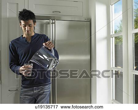 Man pouring water into glass View Large Photo Image Stock Photo - Man pouring water into glass. Fotosearch