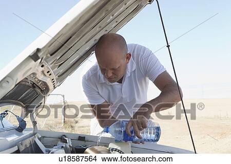 Man pouring water on car engine View Large Photo Image Picture - Man pouring water on car engine. Fotosearch