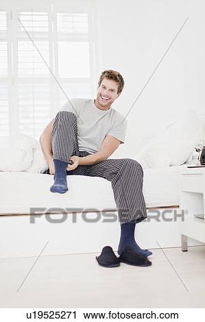 Man putting socks on in bed View Large Photo Image Stock Image - Man putting socks on in bed. Fotosearch