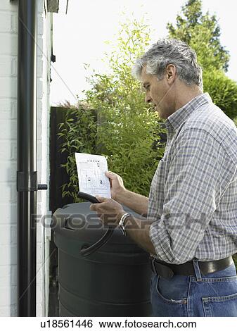 Man reading instructions in backyard View Large Photo Image Stock Photograph - Man reading instructions in backyard. Fotosearch