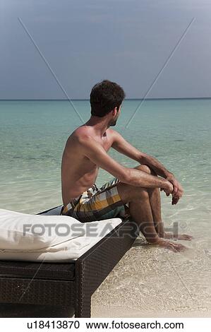 Man relaxing on daybed at tropical beach View Large Photo Image Stock Image - Man relaxing on daybed at tropical beach. Fotosearch