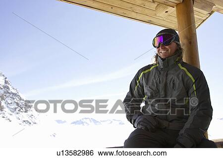 Man relaxing on ski lodge balcony View Large Photo Image Stock Photograph - Man relaxing on ski lodge balcony. Fotosearch