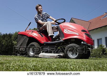 Man riding lawn mower in backyard View Large Photo Image Stock Photo - Man riding lawn mower in backyard. Fotosearch