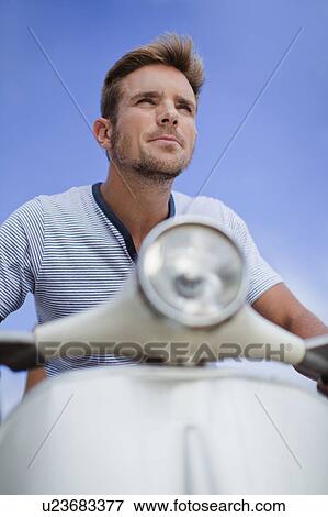 Stock Photo - Man riding scooter. Fotosearch
