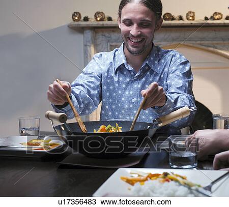 Man serving dinner from wok View Large Photo Image Stock Image - Man serving dinner from wok. Fotosearch