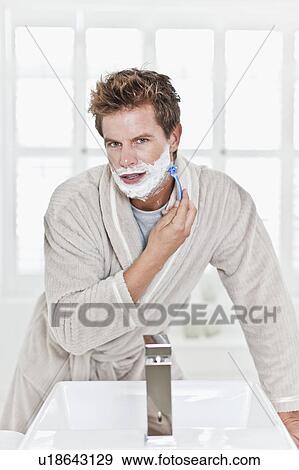 Stock Photo - Man shaving in bathroom. Fotosearch