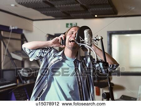 Man singing in recording studio View Large Photo Image Stock Image - Man singing in recording studio. Fotosearch