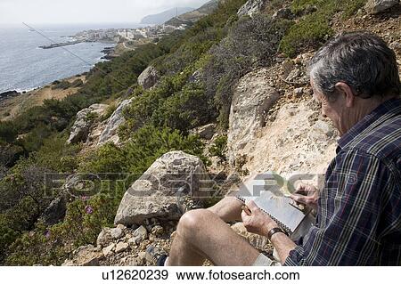 Man sketching on hillside View Large Photo Image Stock Photo - Man sketching on hillside. Fotosearch