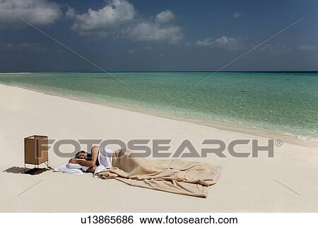 Man sleeping in bed on beach View Large Photo Image Stock Photograph - Man sleeping in bed on beach. Fotosearch