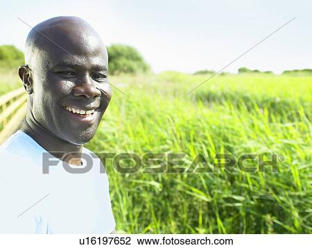 Man smiling in field of flowers View Large Photo Image Stock Image - Man smiling in field of flowers. Fotosearch