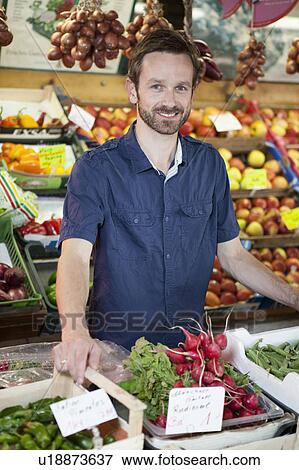 Stock Photo - Man smiling in produce stand. Fotosearch