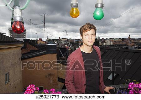 Man standing on balcony overlooking city View Large Photo Image Stock Photo - Man standing on balcony overlooking city. Fotosearch