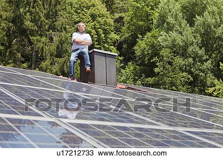 Man standing on solar paneled roof View Large Photo Image Stock Image - Man standing on solar paneled roof. Fotosearch
