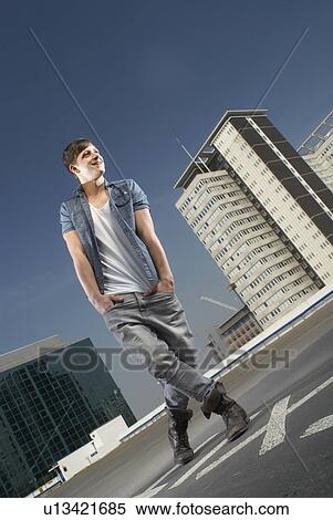 Man standing on urban rooftop View Large Photo Image Stock Photography - Man standing on urban rooftop. Fotosearch