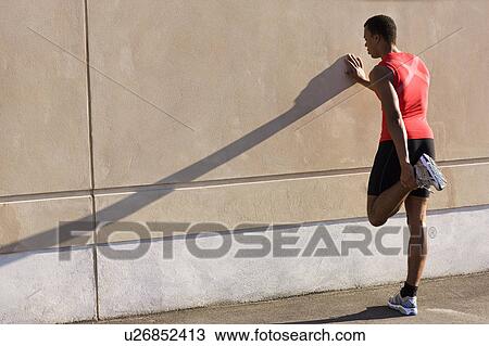 Man stretching against wall View Large Photo Image Stock Image - Man stretching against wall. Fotosearch