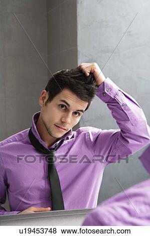 Stock Photo - Man styling his hair in mirror. Fotosearch