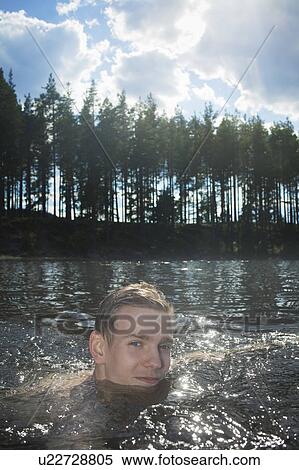 Stock Photography - Man swimming in rural lake. Fotosearch