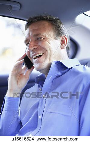 Picture - Man talking on cell phone in car. Fotosearch
