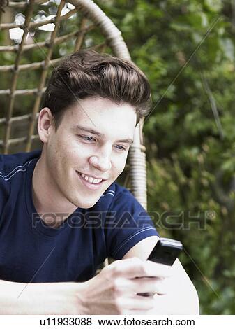 Man using cell phone in chair swing View Large Photo Image Stock Photo - Man using cell phone in chair swing. Fotosearch