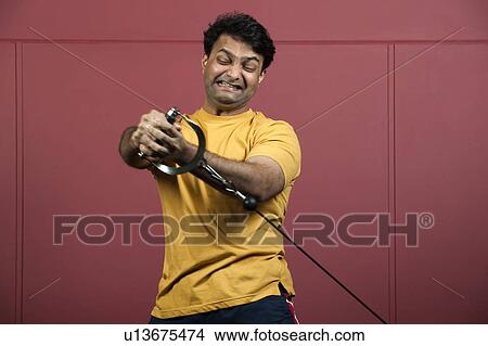 Man using exercise machine in gym View Large Photo Image Picture - Man using exercise machine in gym. Fotosearch