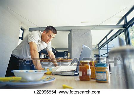 Man using laptop at breakfast View Large Photo Image Picture - Man using laptop at breakfast. Fotosearch