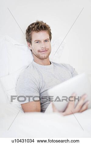 Man using laptop in bed View Large Photo Image Picture - Man using laptop in bed. Fotosearch
