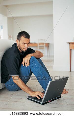 Man using laptop on floor View Large Photo Image Stock Image - Man using laptop on floor. Fotosearch