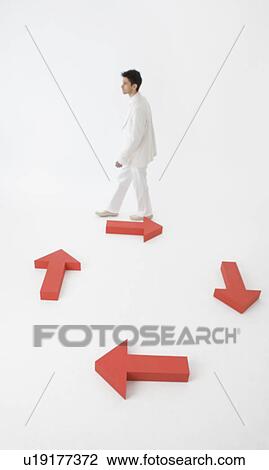 Man walking against directional arrows View Large Photo Image Stock Image - Man walking against directional arrows. Fotosearch