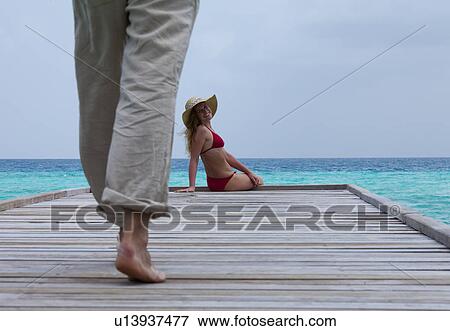 Stock Photo - Man walking towards woman on deck. Fotosearch